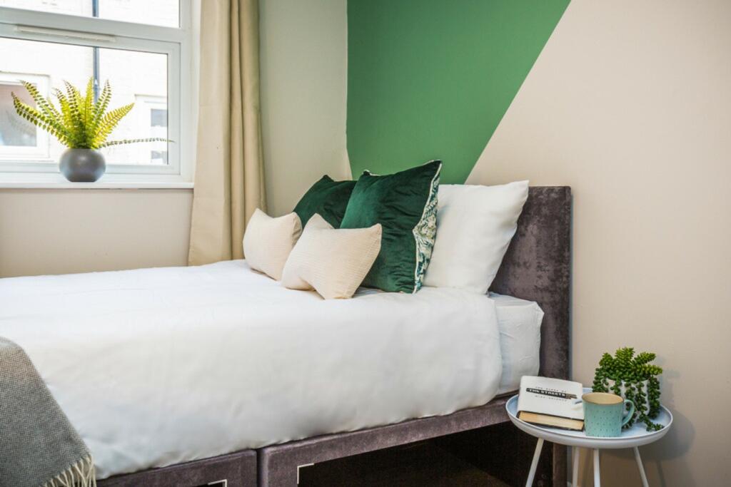 A bright and inviting double bedroom featuring ...