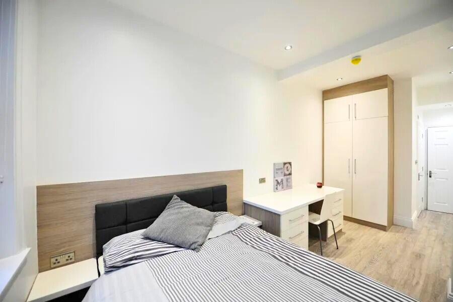 Bright and modern single bedroom featuring a co...