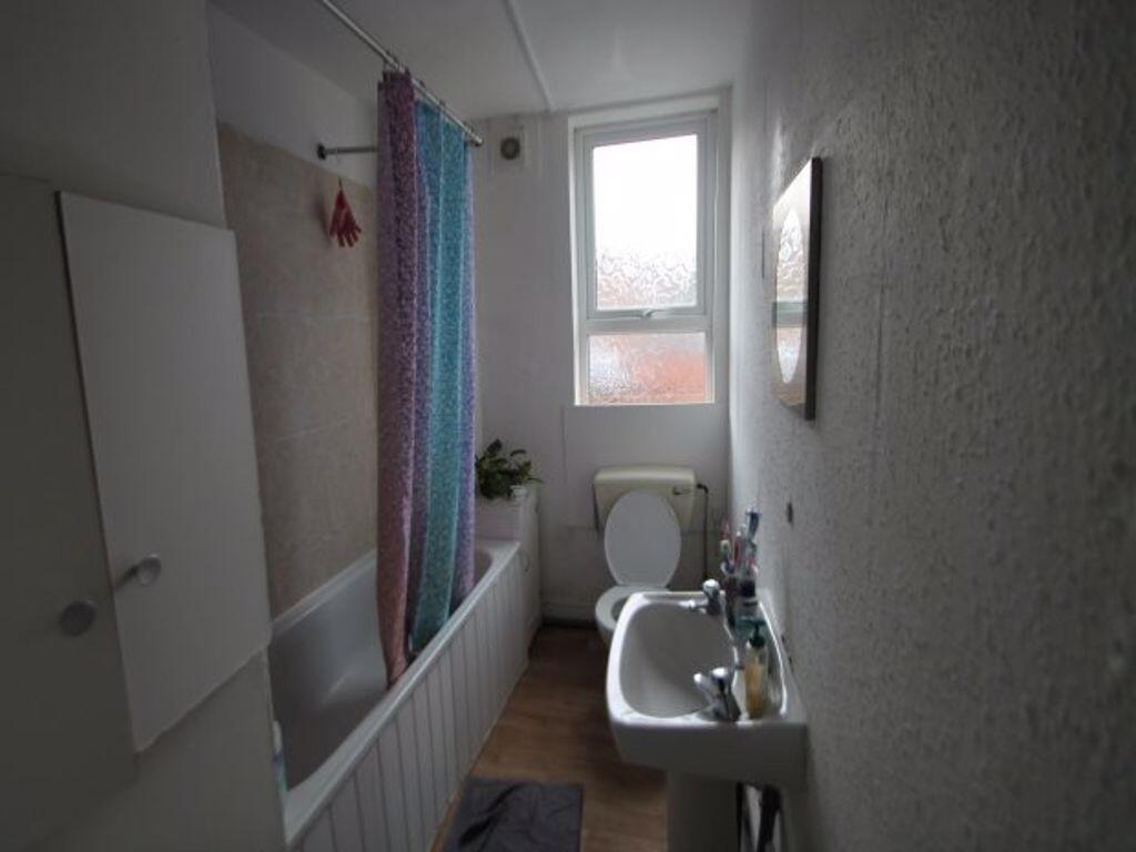 A clean and functional bathroom with a bathtub,...