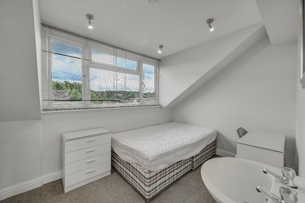 A bright and clean single bedroom featuring a l...