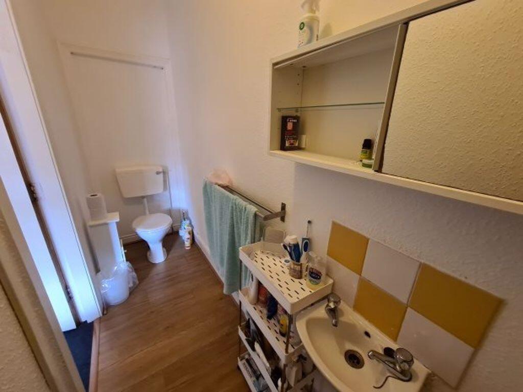 Compact bathroom with a toilet, sink with vanit...