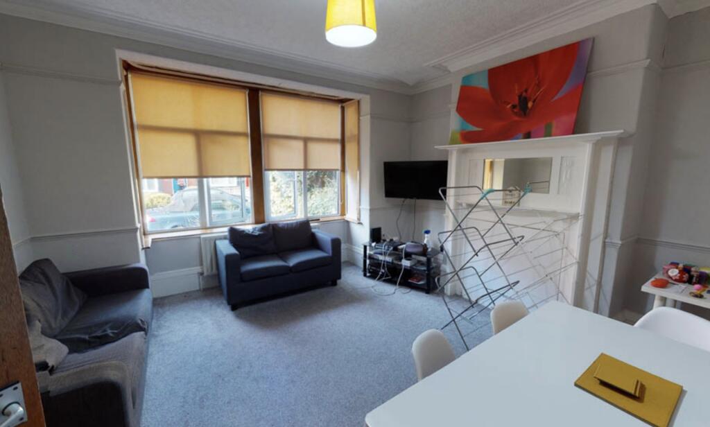 A spacious, well-lit living area featuring comf...