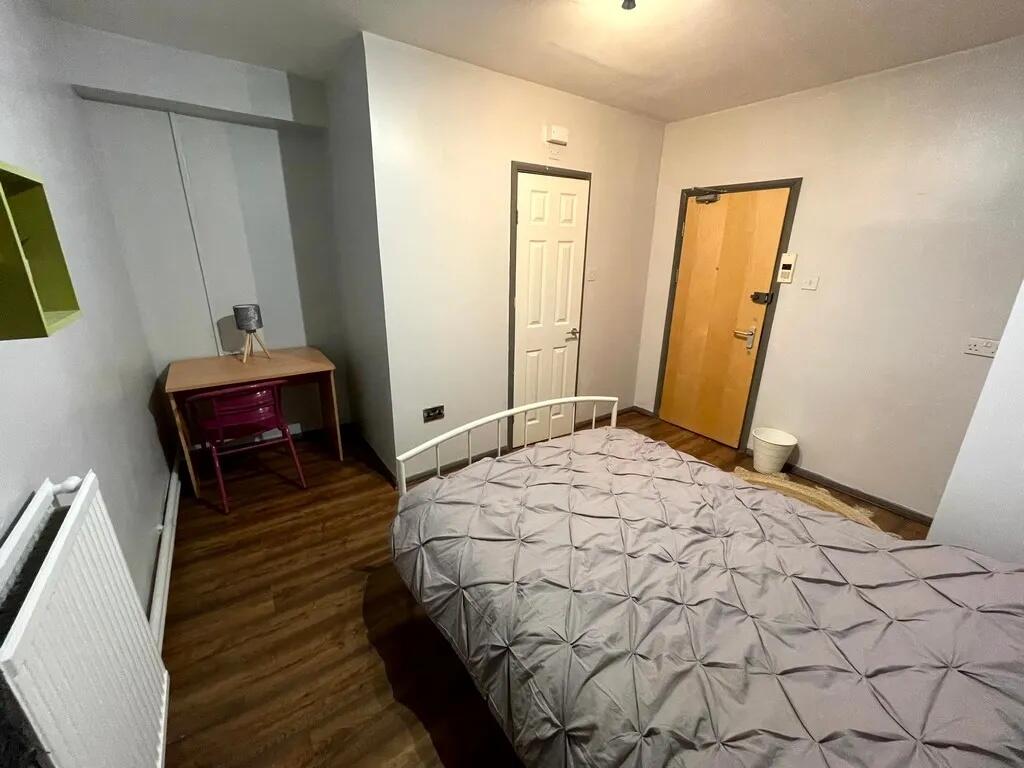 A neat and tidy single bedroom featuring a comf...
