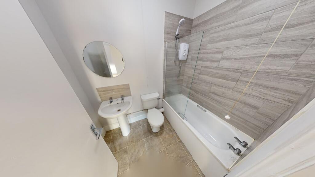 A modern bathroom featuring a bathtub with an o...