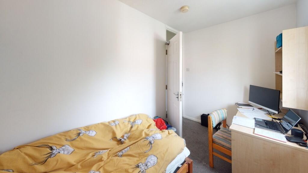 A compact single bedroom featuring a cozy singl...