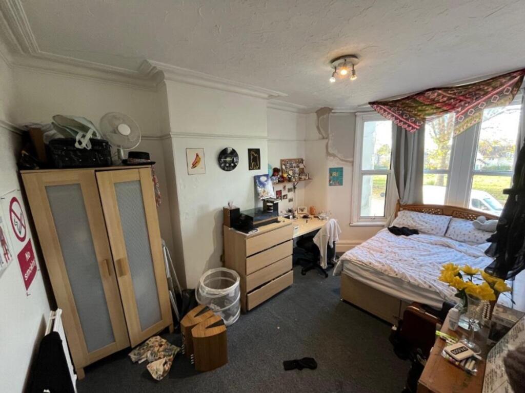 A spacious double bedroom with ample natural li...