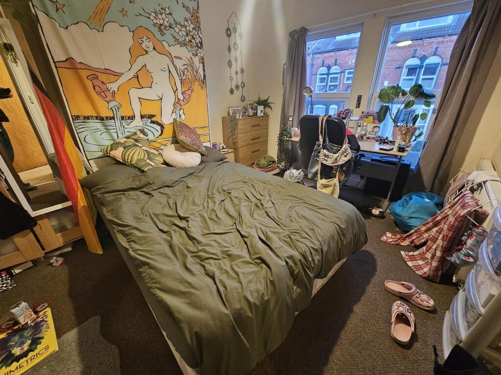 Cosy double bedroom with a large bed, colourful...
