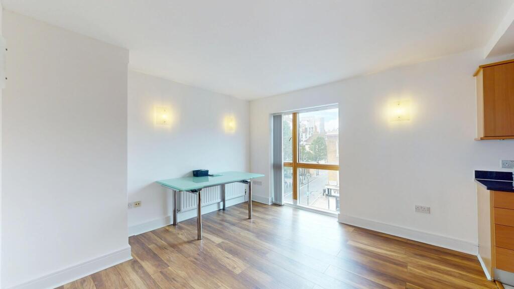 A spacious, bright living room with large windo...