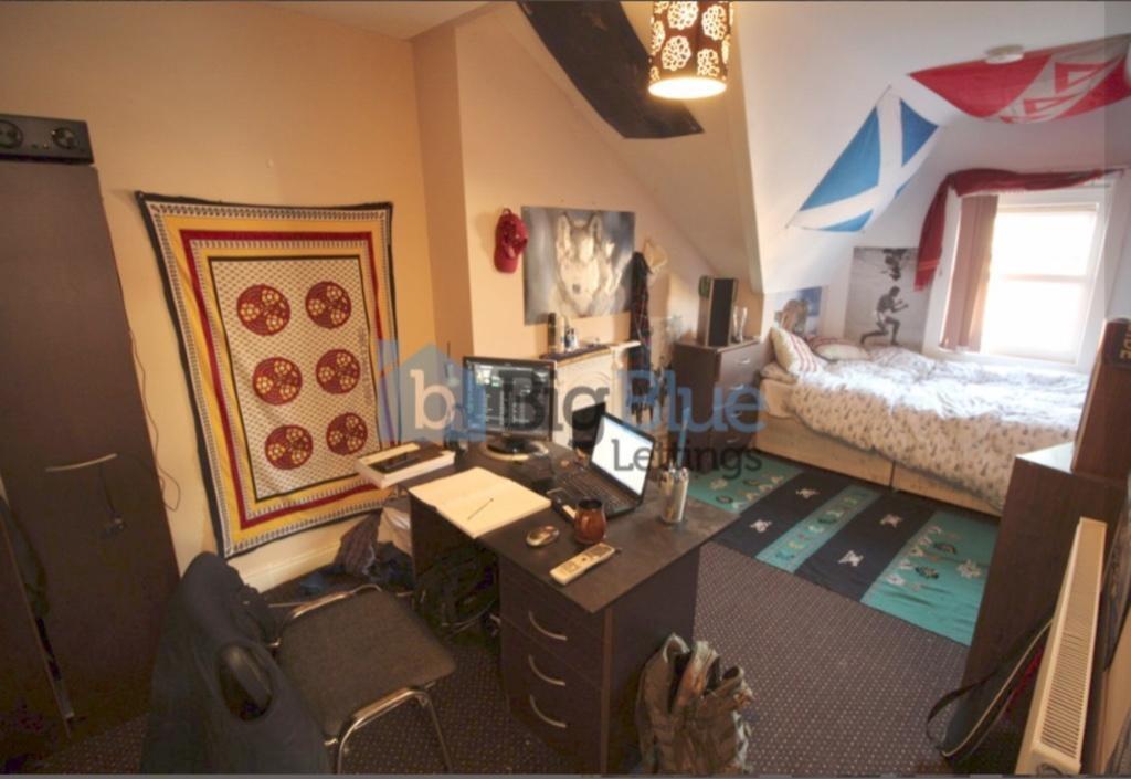 Cozy single bedroom featuring a comfortable bed...