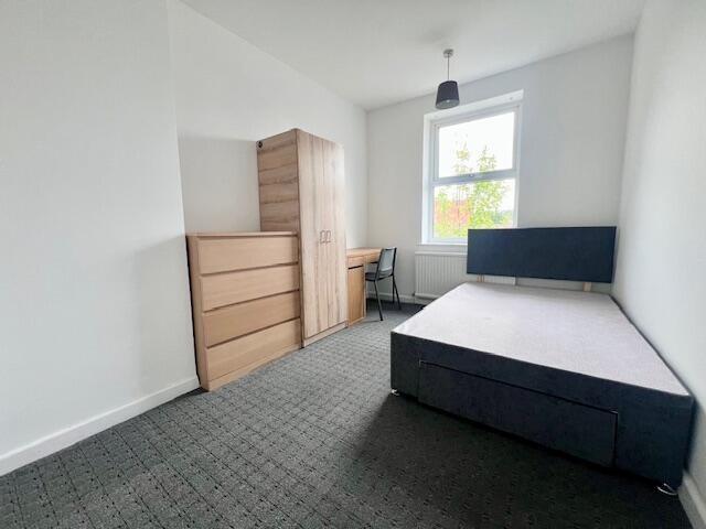 A bright and tidy single bedroom featuring a la...