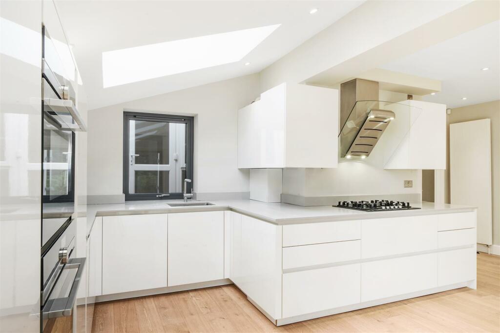 White laquerd kitchen with marble worktops
