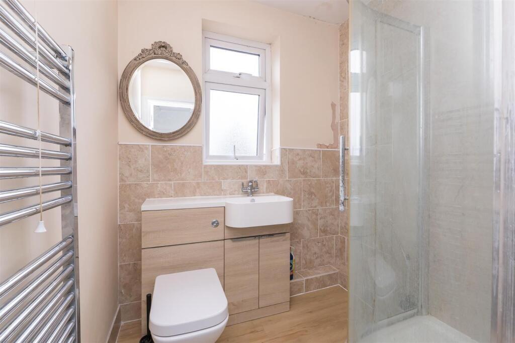 A modern bathroom featuring a clear glass showe...