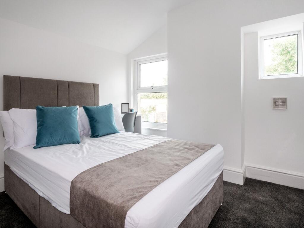 A bright and modern double bedroom featuring a ...