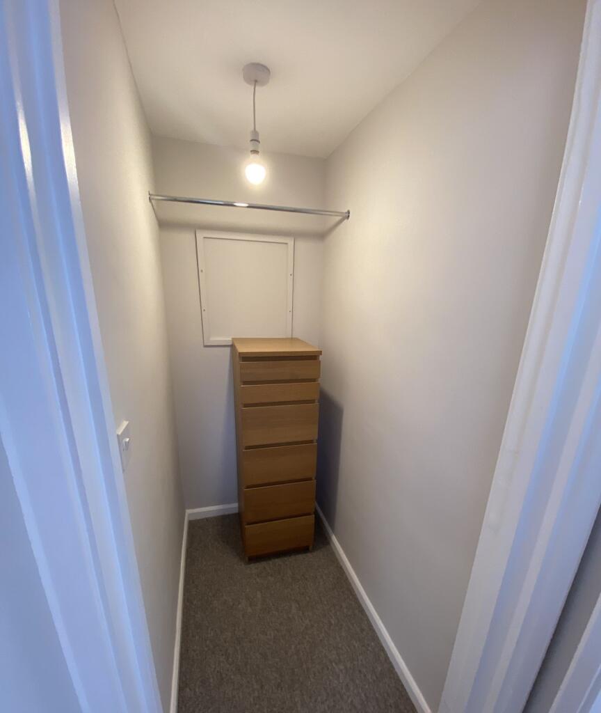 A well-maintained, narrow storage room featurin...