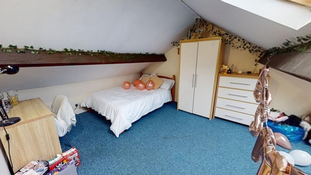 Cozy attic bedroom featuring a single bed, ward...