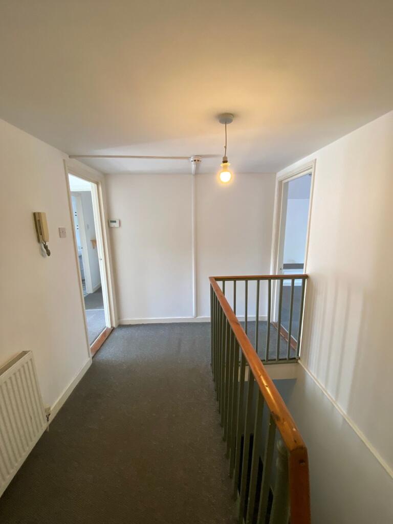 A bright and clean hallway featuring neutral wa...