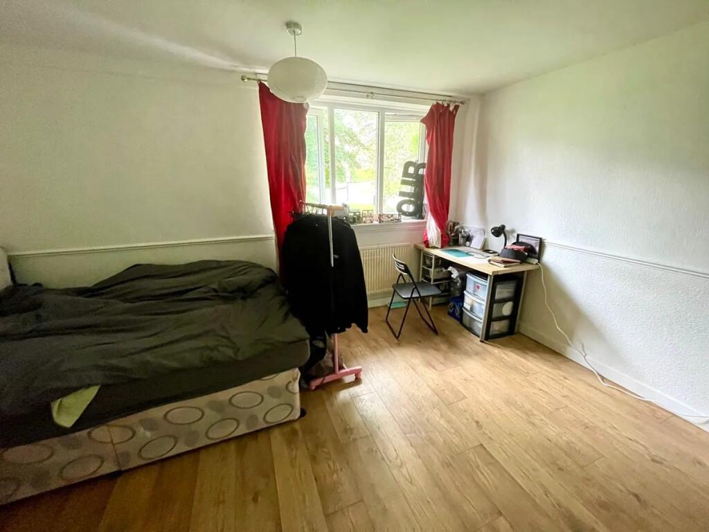 A cozy single bedroom featuring a comfortable b...