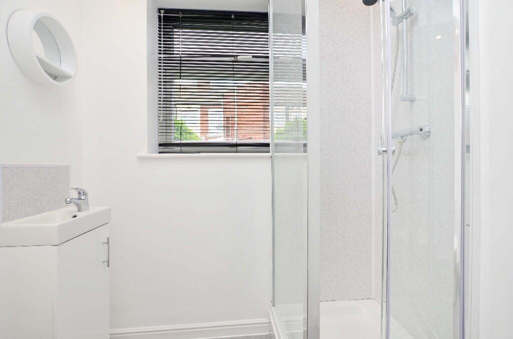 A bright and modern bathroom featuring a clear ...
