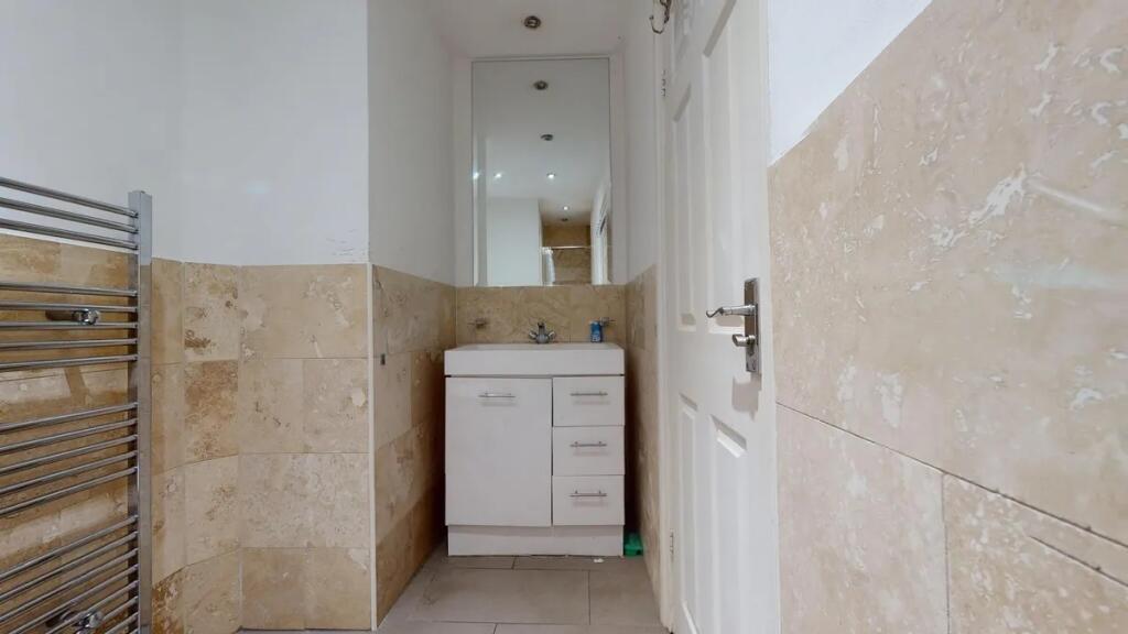A clean and modern hallway featuring beige tile...