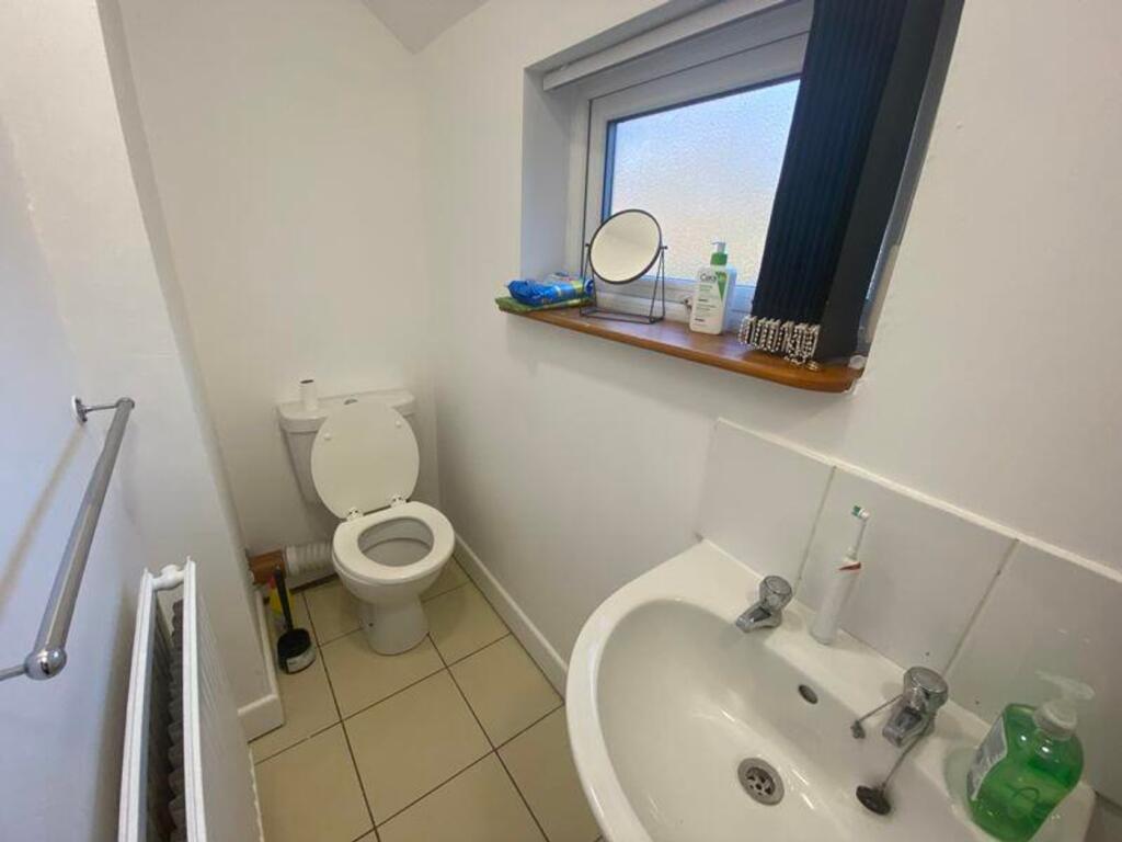 A tidy single toilet with natural light and mod...