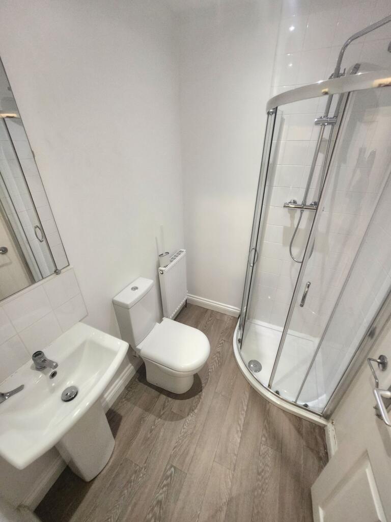 A clean and modern bathroom featuring a corner ...