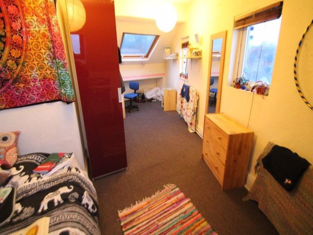 A cozy single bedroom featuring a colorful tape...