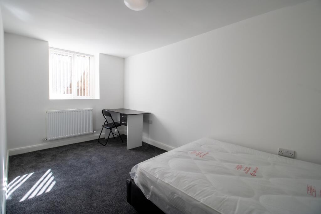 A bright and clean bedroom featuring a double b...