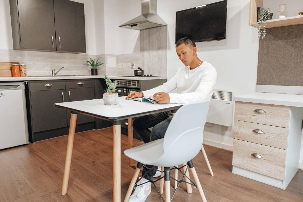 Modern kitchen area featuring sleek cabinetry, ...