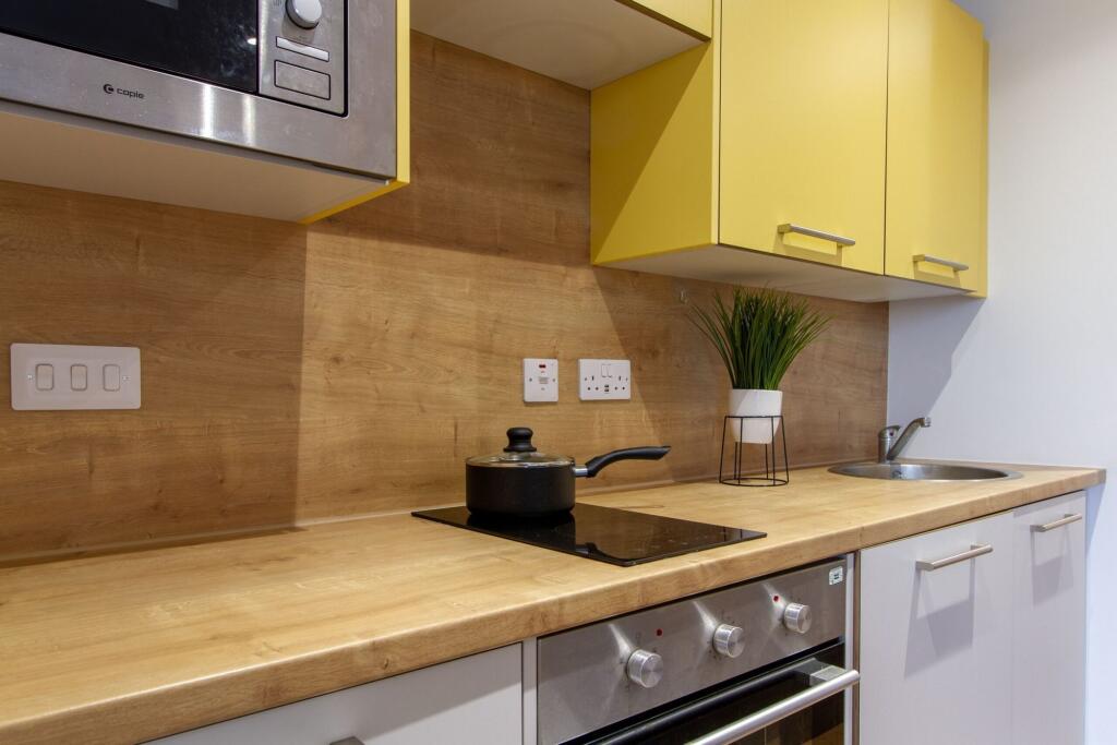 A modern kitchen featuring bright yellow upper ...