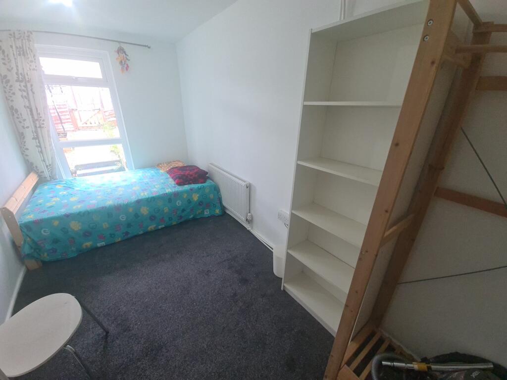 A bright and tidy single bedroom featuring a co...