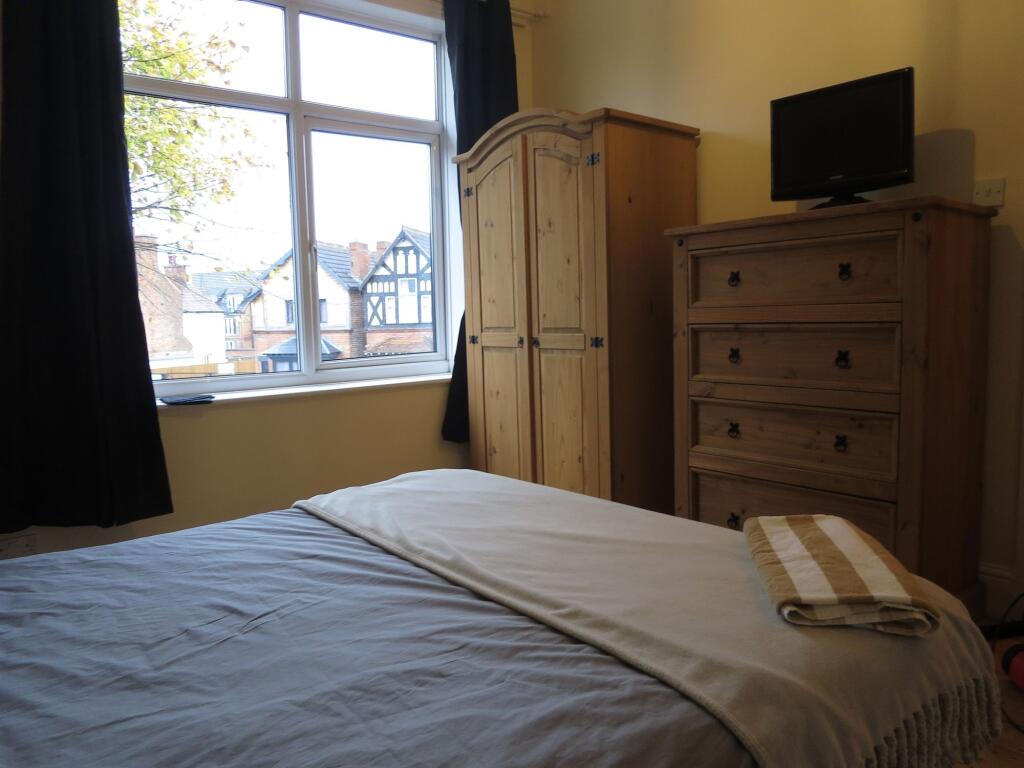 A cozy bedroom featuring a large window that al...