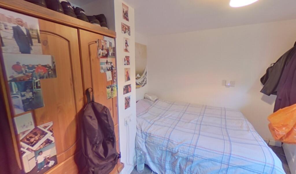 Cozy single bedroom featuring a neatly made bed...