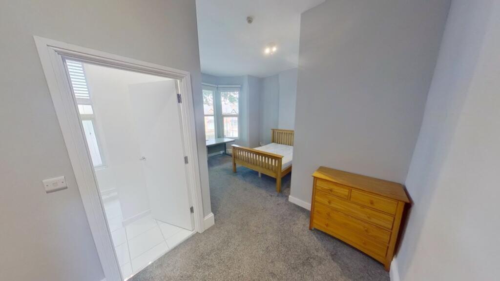 A spacious and well-lit double bedroom featurin...