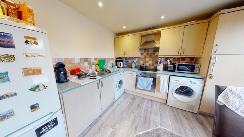 Bright, modern kitchen with ample storage and i...