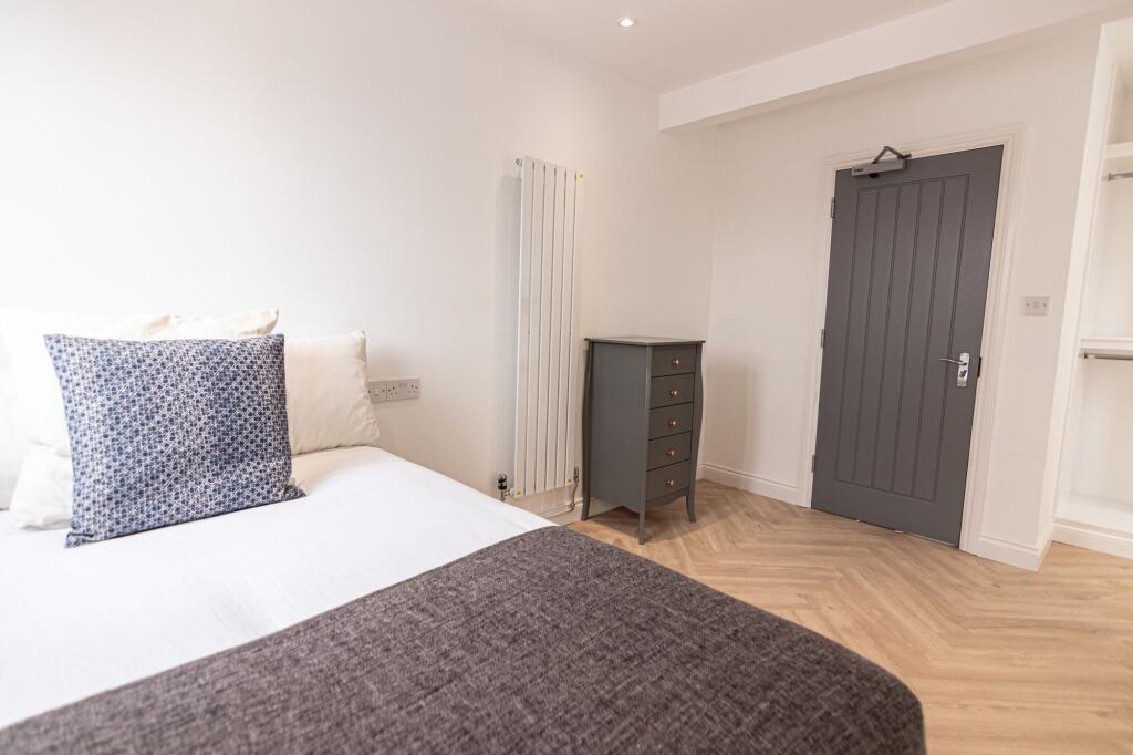 A bright and welcoming double bedroom featuring...