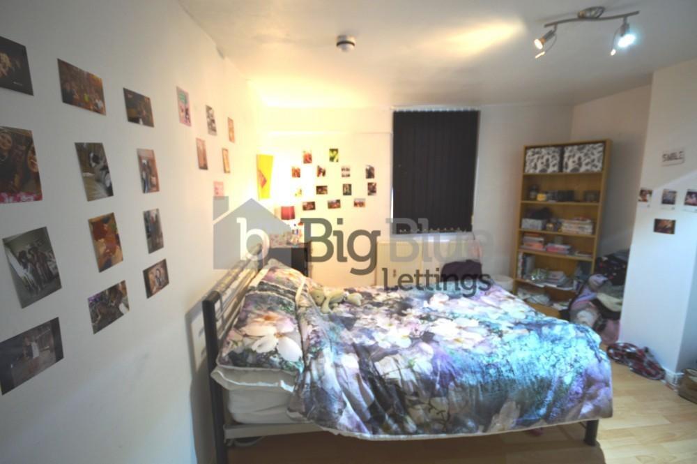 A cozy double bedroom with a wooden floor and a...