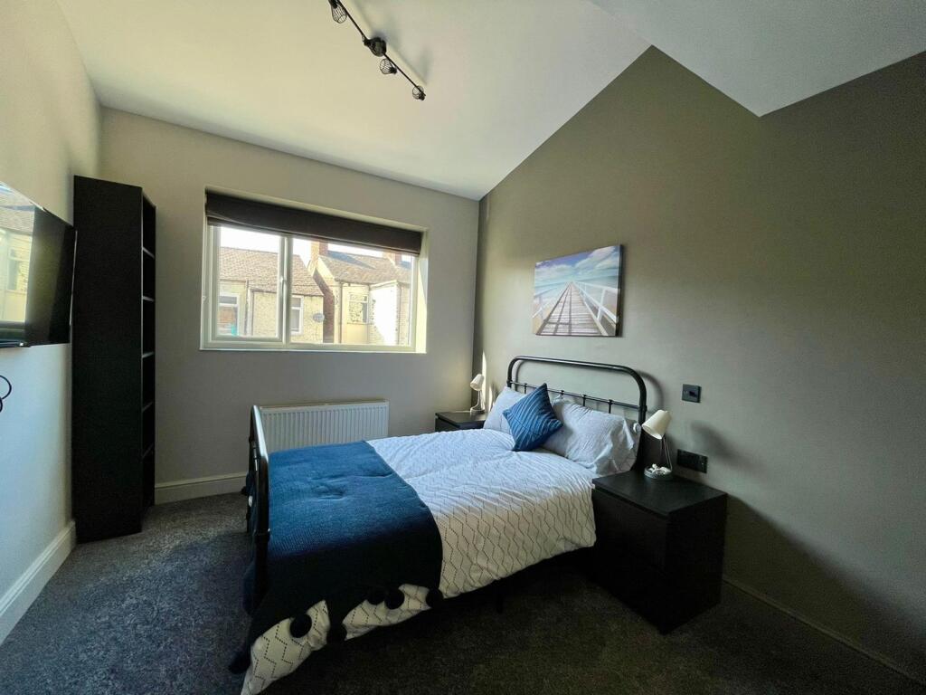This inviting double bedroom features a comfort...