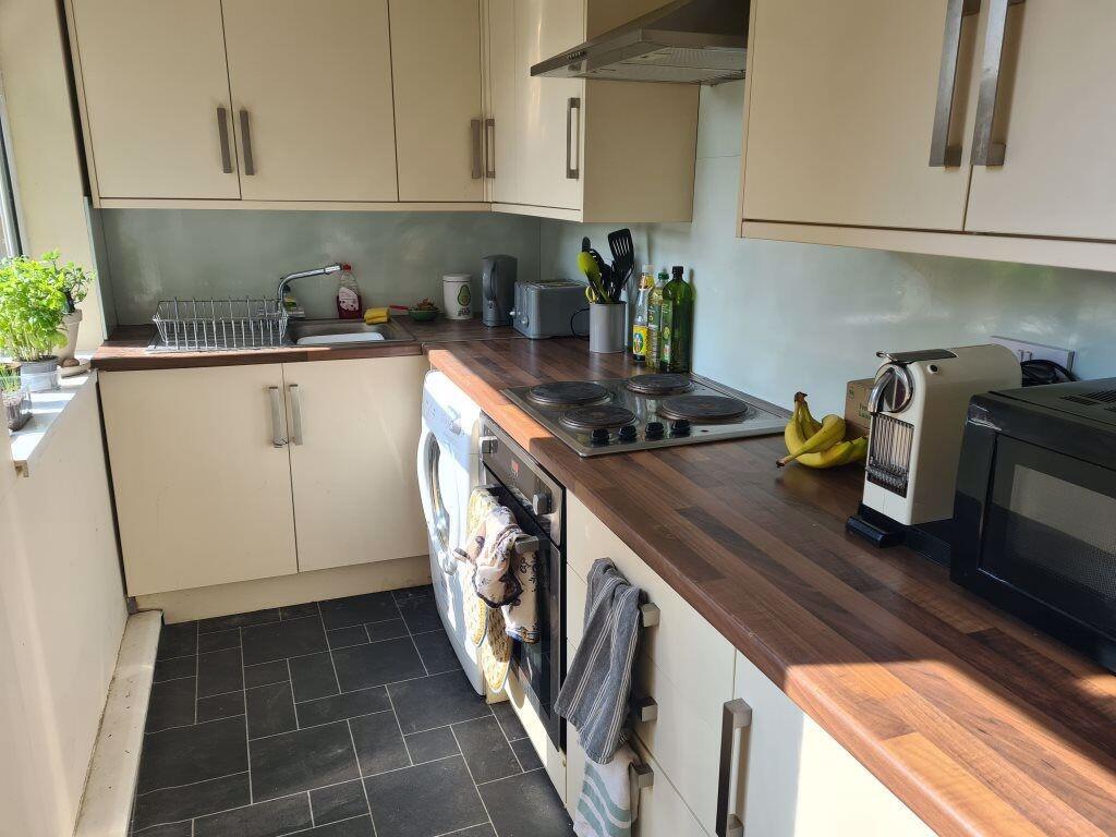A modern and tidy kitchen featuring wooden coun...