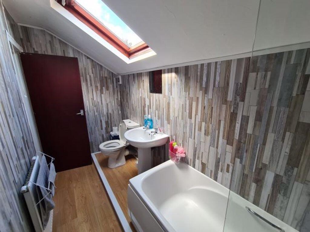 A well-maintained bathroom featuring a bathtub,...