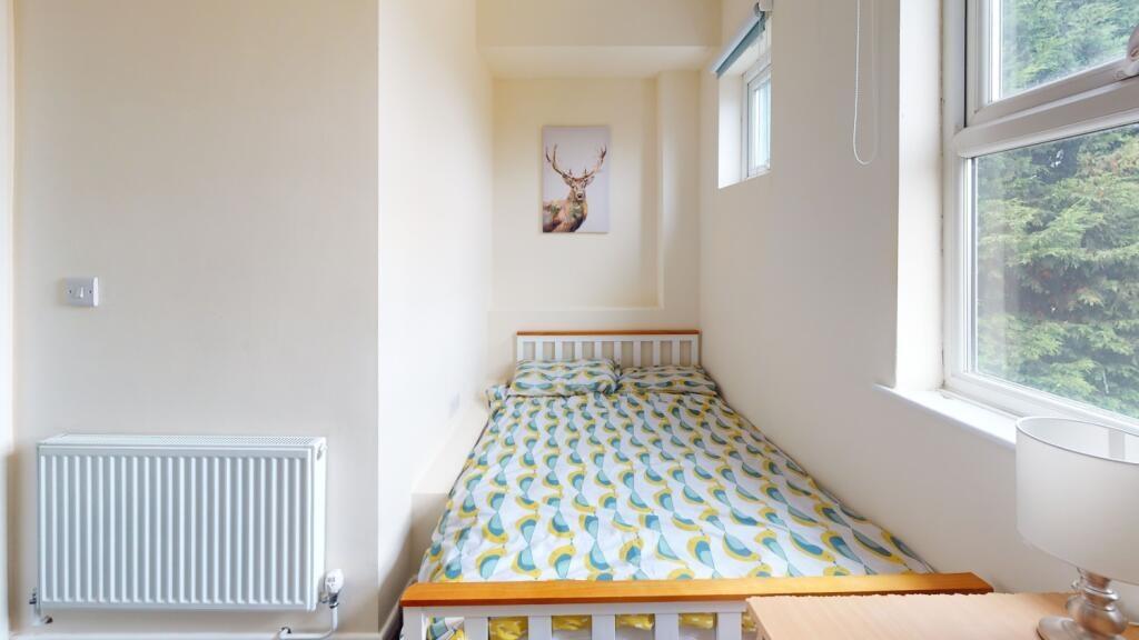 A bright and tidy single bedroom featuring a co...