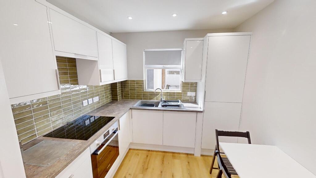 A bright and modern kitchen featuring white cab...