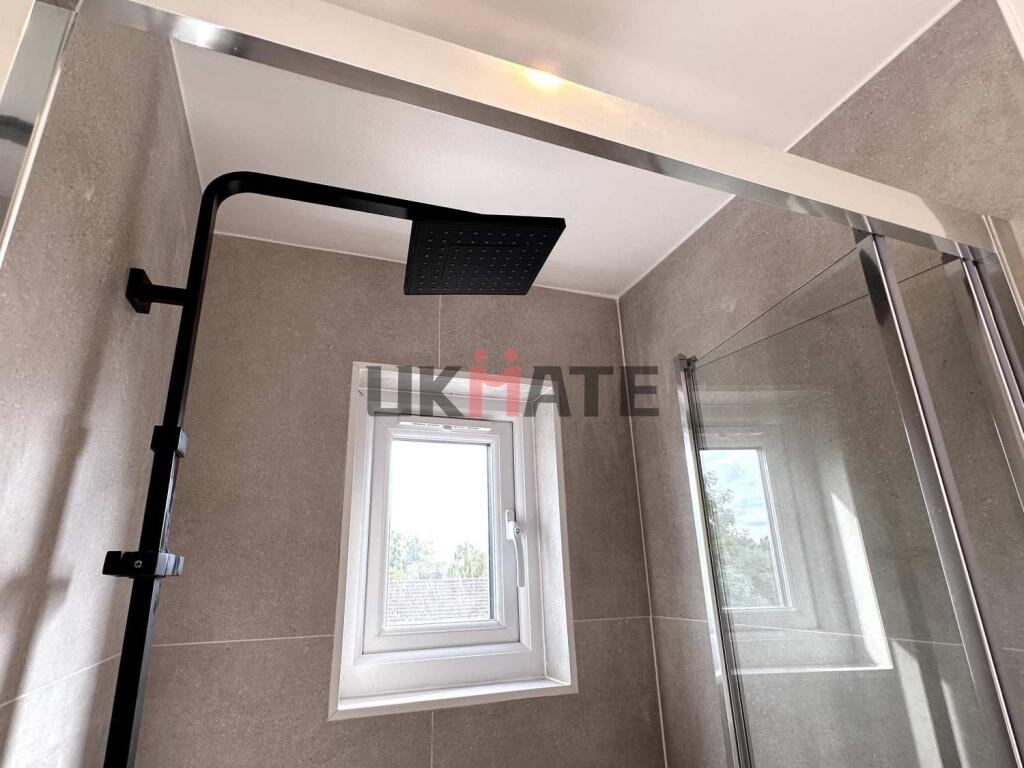 A modern bathroom featuring a sleek walk-in sho...
