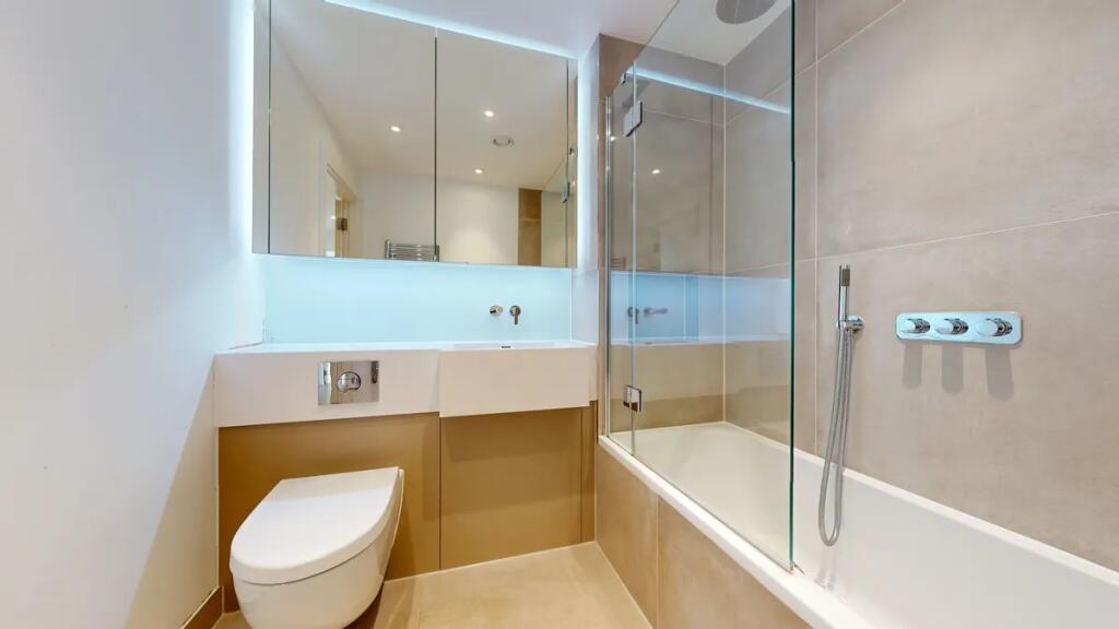 A modern and spotless bathroom suite featuring ...