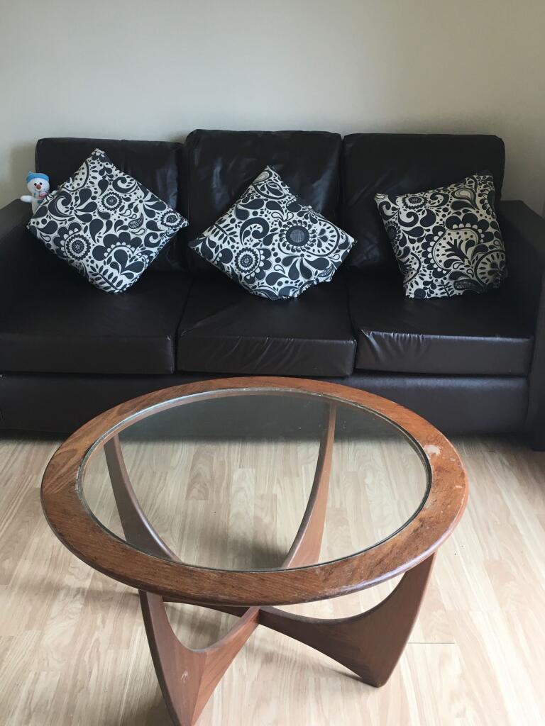 A cozy living room featuring a dark leather thr...