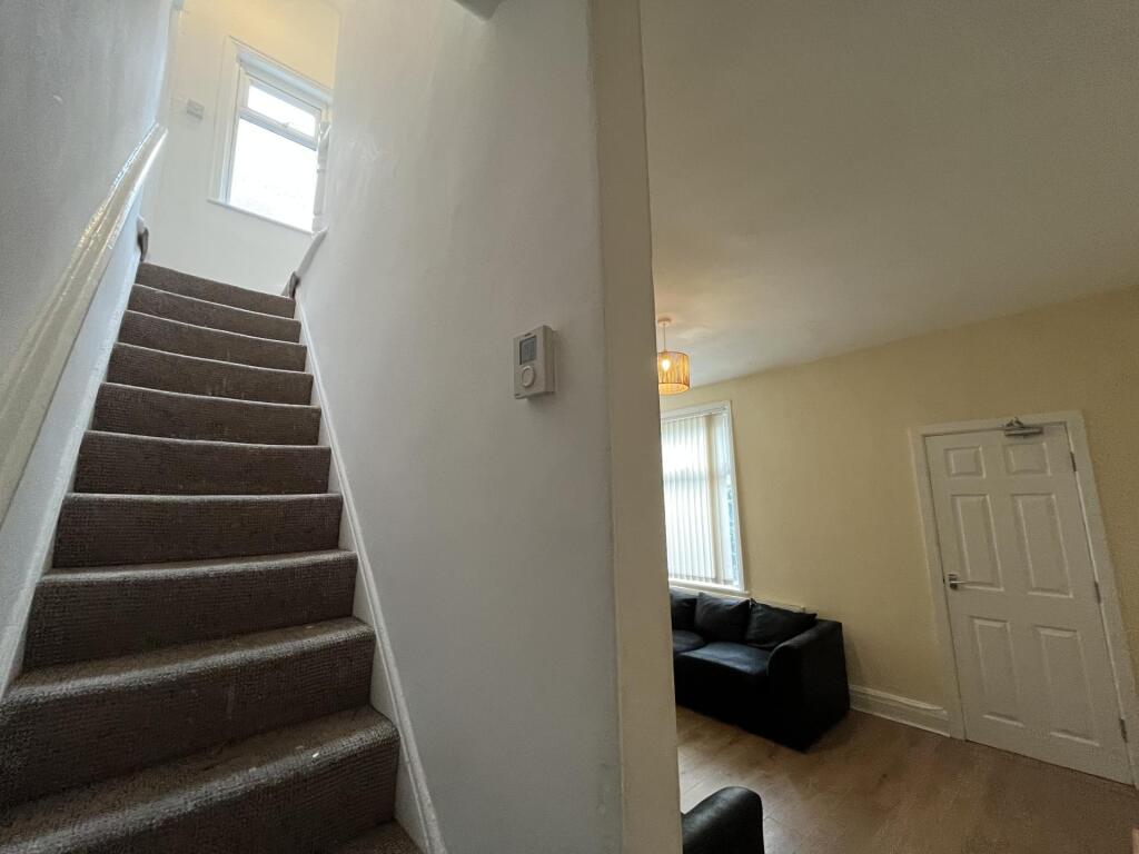 A bright and tidy staircase area leading up to ...