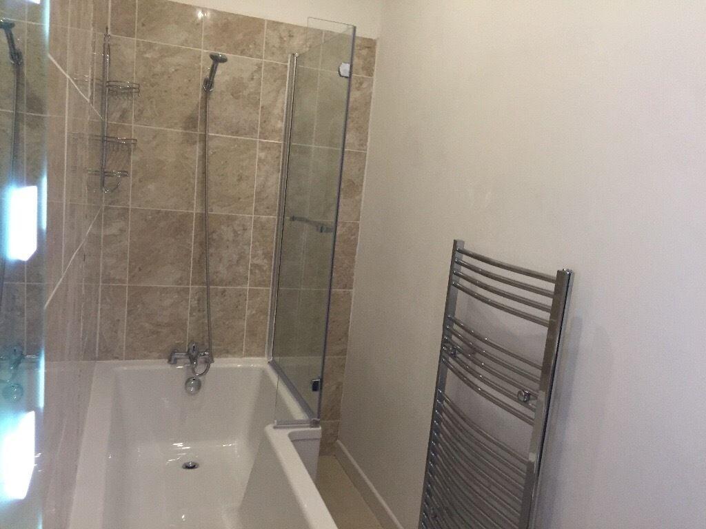 A modern bathroom suite featuring a clean, whit...