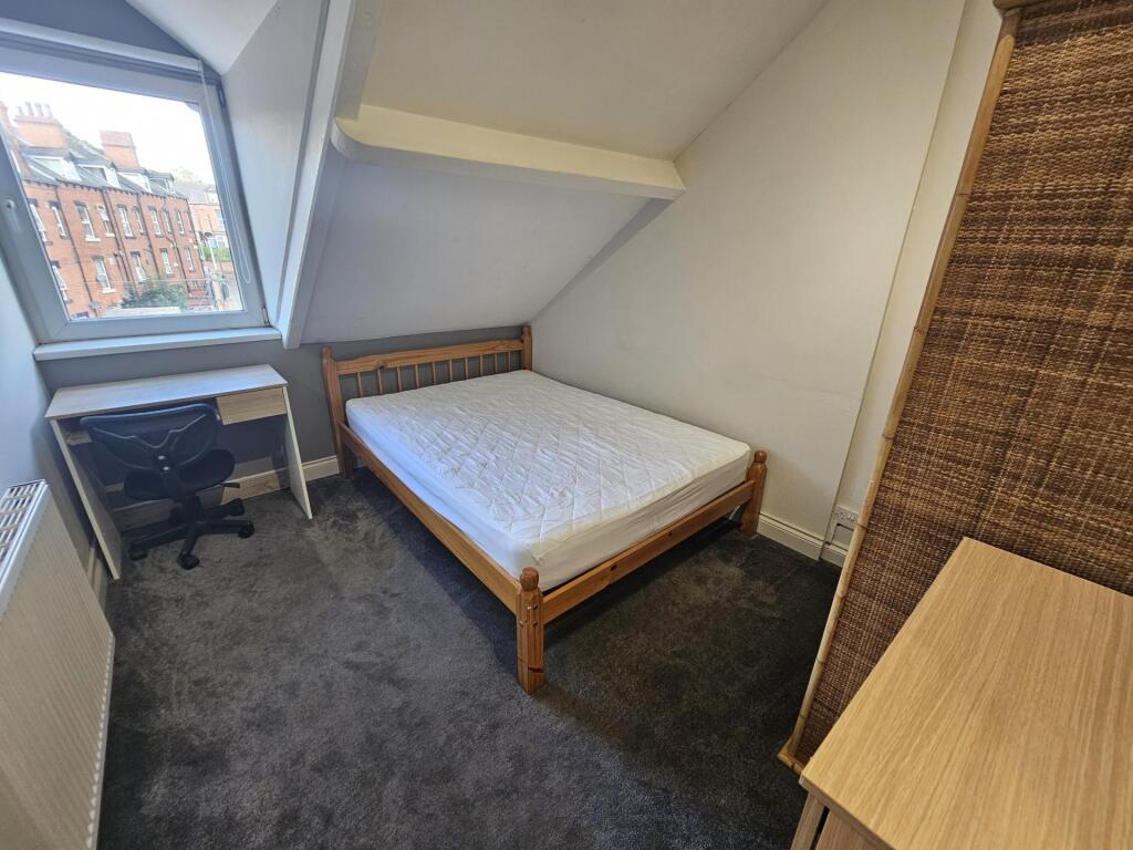 A cozy single bedroom featuring a comfortable b...