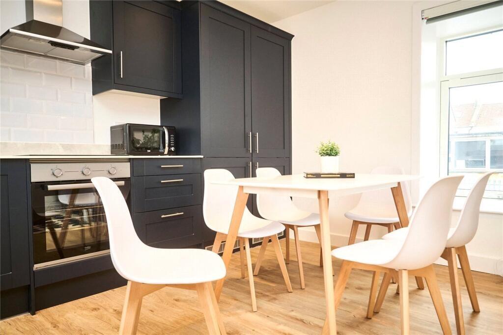 Bright and modern kitchen featuring sleek black...