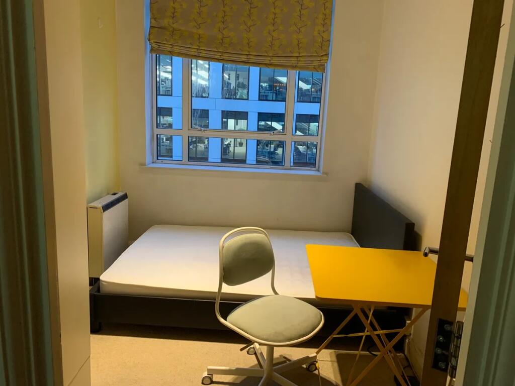 A neat and simple single bedroom featuring a co...