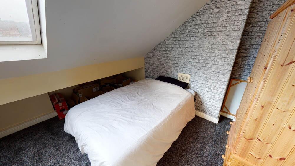 Cozy single bedroom featuring a comfortable bed...